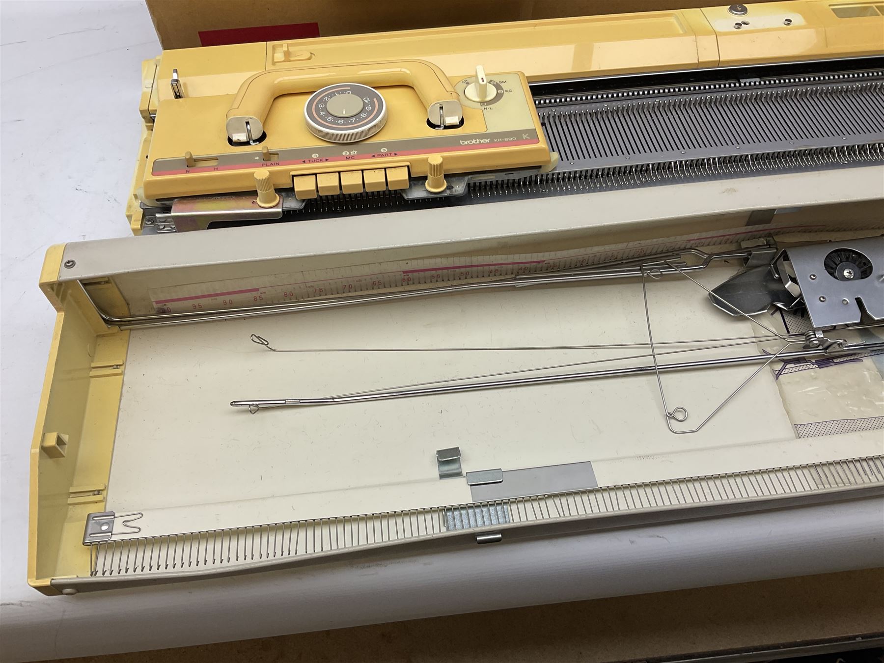  Brother cased knitting machine model KH-890 together with Brother Ribbing attachment model KH-850, knitting machine yarn cones in assorted colours, selection of knitting patterns etc