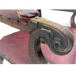 Late Victorian Gothic-revival armchair, arched crest rail carved with tracery and trefoil detail, padded circular back and seat, brass studded burgundy leather upholstery, shaped armrests with scrolled terminals, on square tapering supports