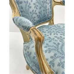 Pair French style bedroom armchairs, moulded frames and scroll carved arms, serpentine seat with cabriole supports, upholstered in a light blue foliate pattern fabric, sprung seat