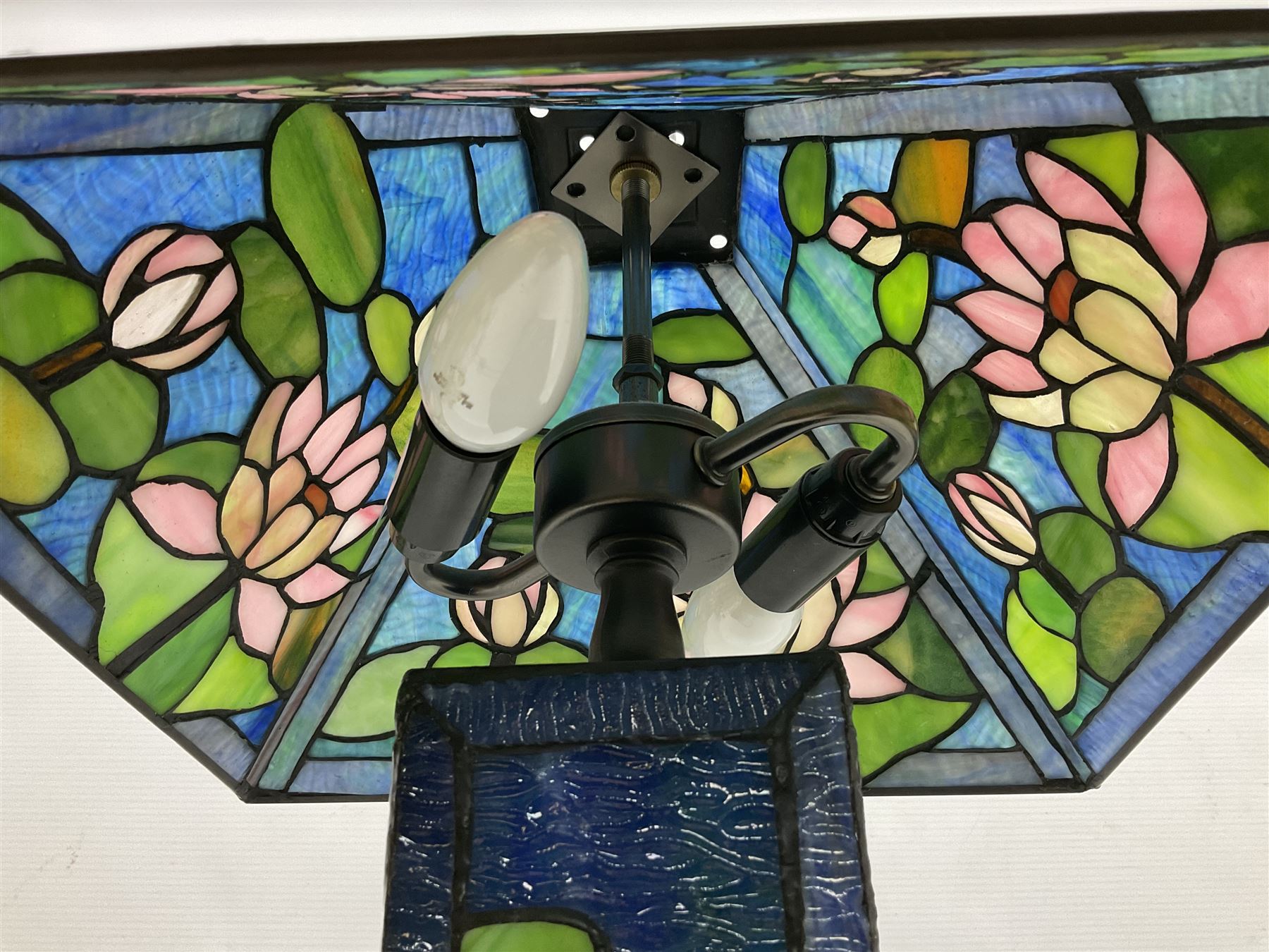 Tiffany Pond Lily style table lamp and shade with leaded panels of green, pink and rippled blue water effect ground, raised upon brushed metal base, H50cm