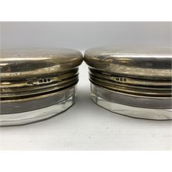 Pair of early 20th century glass dressing table jars, or circular facet cut form, with silver covers, hallmarked London, probably 1912