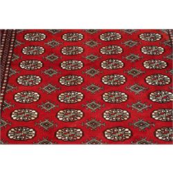 Two Afghan Bokhara crimson ground rugs, the fields decorated with repeating Gul motifs with geometric guard bands (126x190 & 157x250)