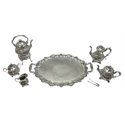 Edwardian silver plated five piece tea service on tray, comprising kettle on stand, teapot, coffee pot, twin handled sucrier and cover, and cream jug, each of bellied form with embossed and chased foliate and C scroll decoration to bodies, the spouts with mask and zoomorphic detail, the covers with bird finials, each upon four scroll feet, the twin handled tray with shaped and scrolling rim, and engraved foliate decoration to centre, L71cm