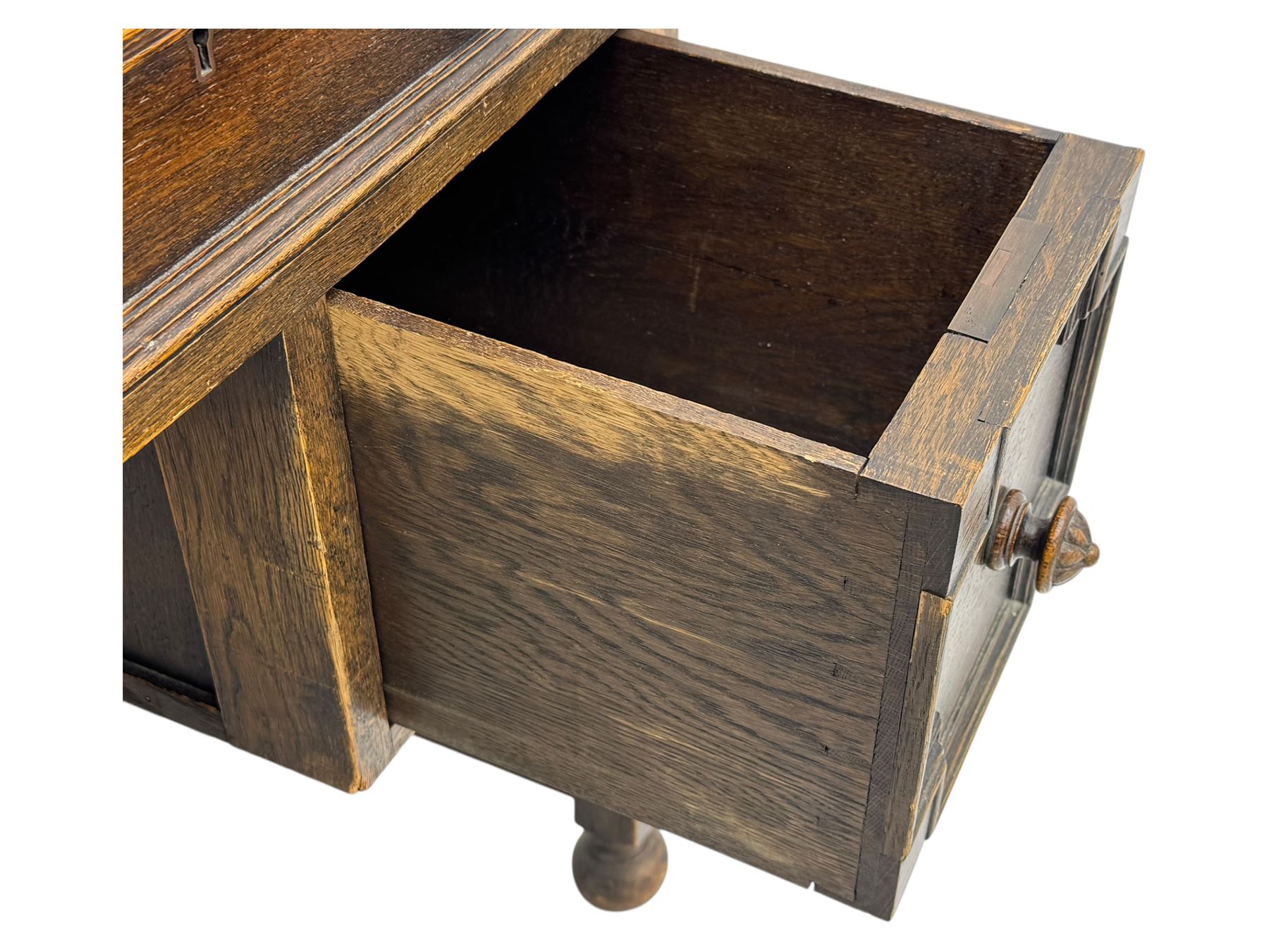 Early 20th century Jacobean design oak desk, with rectangular top inset with worn tooled leather, two frieze drawers over pedestals each fitted with a pair of panelled drawers, turned handles, on carved and fluted tapering legs united by stretchers 