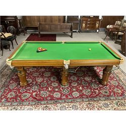 Late 20th century oak slate bed billiard table, on six turned column supports,  together with cues, ball set, baize brush, triangles and scoreboard 