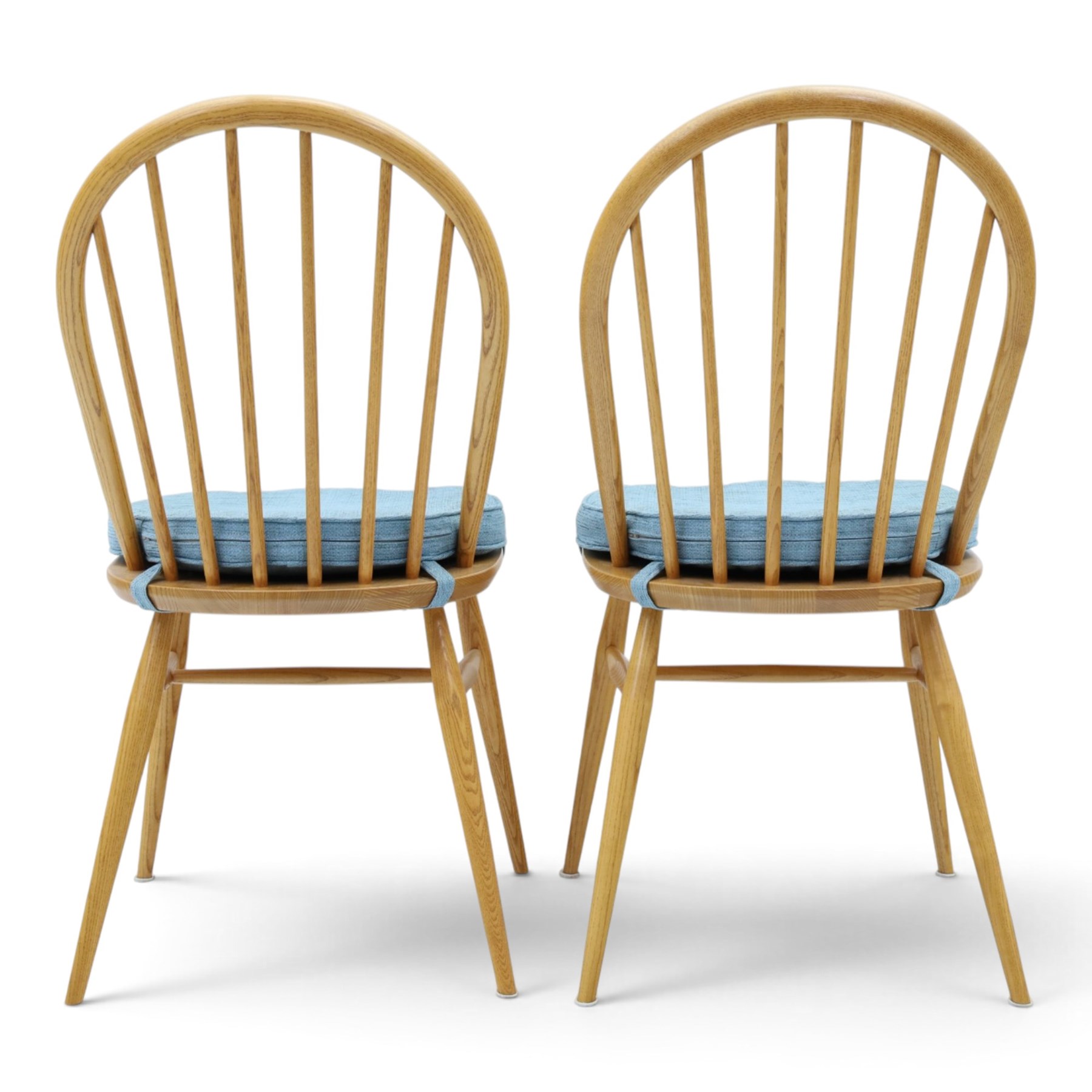 Ercol - pair of 'Windsor' dining chairs, with high hooped back, blue seat cushions with studded, tapered supports  