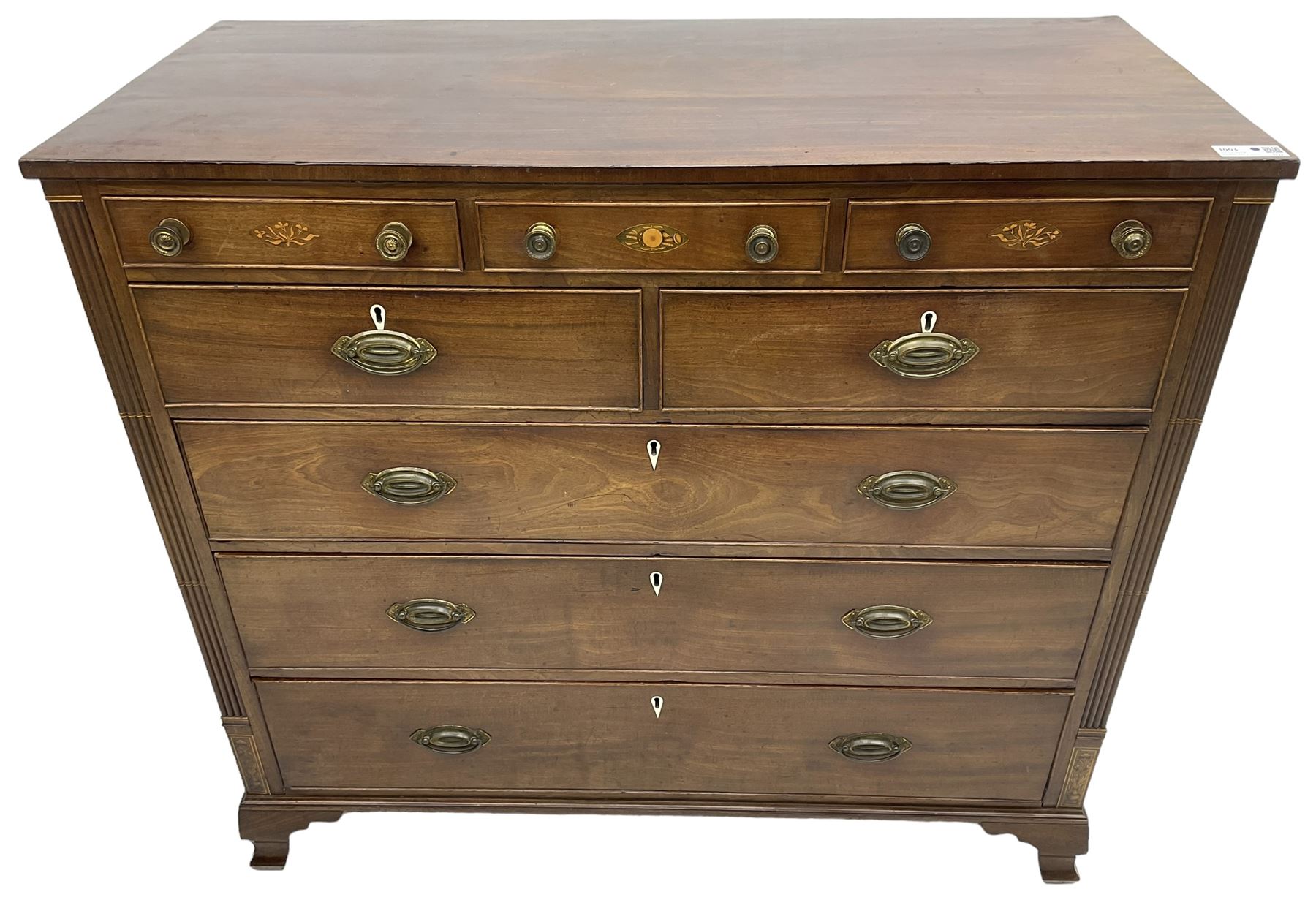 Early 19th century mahogany chest, three shallow frieze drawers over two short and three long cock-beaded drawers, canted corners with reeded moulded square columns, on ogee bracket feet