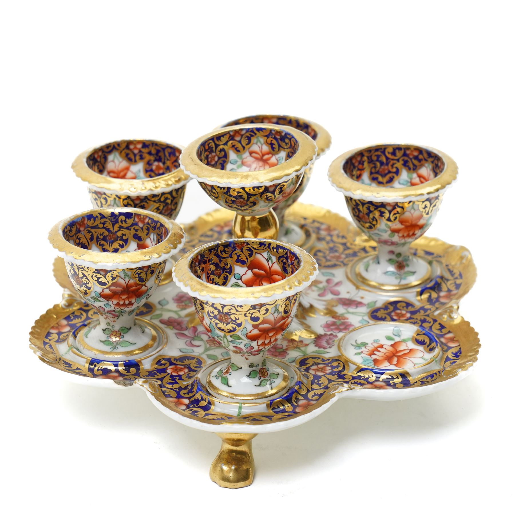 Early 19th century Chamberlain's Worcester egg stand of serpentine circular form fitted with five egg cups and decorated with flowers on a blue and gilt ground with gilt border and on paw feet D20cm. Printed mark used on the Regent body circa 1811-1820 
Provenance: property of a Nobleman