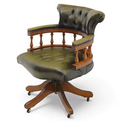 Late 20th century swivel captain’s desk chair, green buttoned vinyl upholstered back and seat with brass stud edging, the spindle gallery over a rotating base with five splayed supports on castors