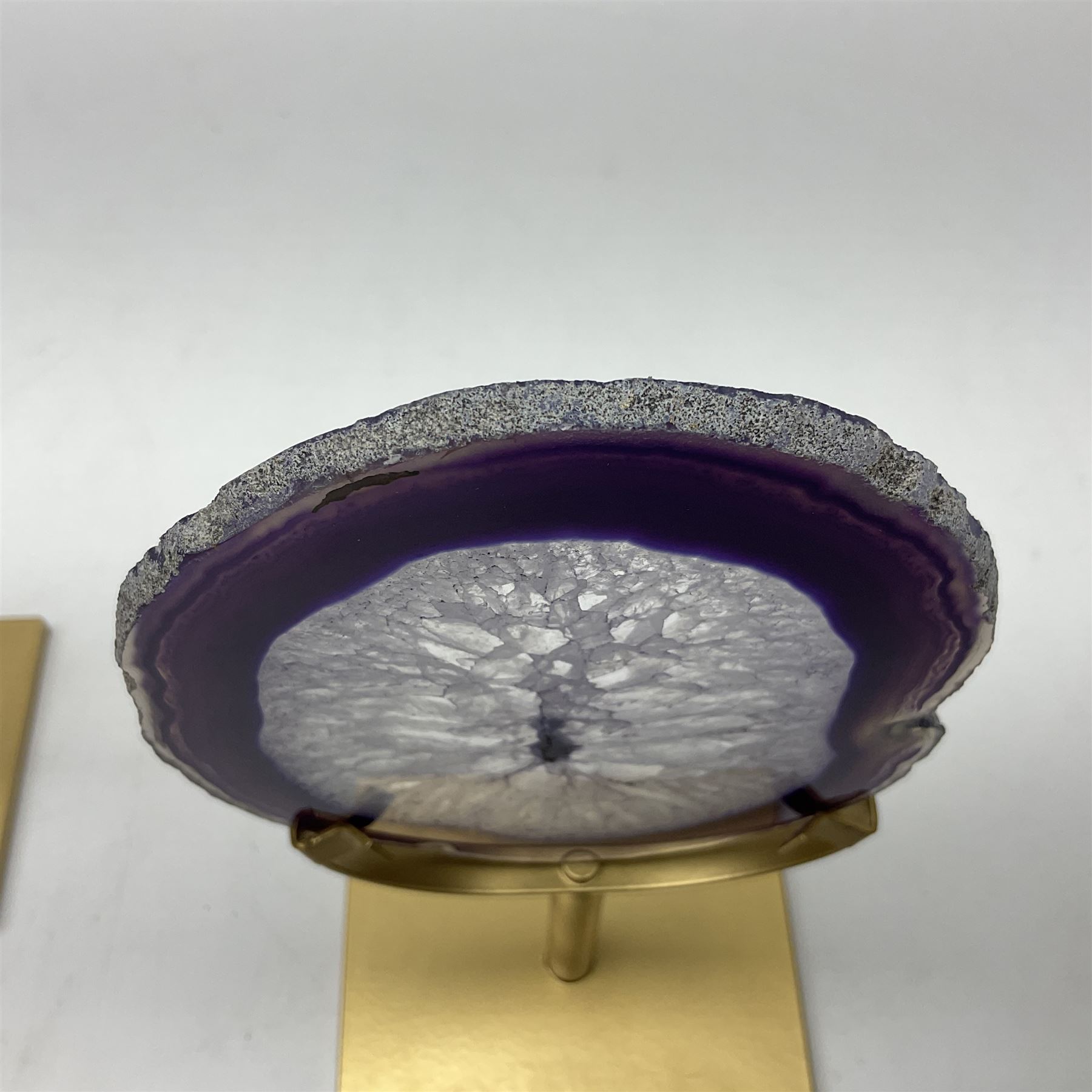 Pair of purple agate slices, polished with rough edges raised upon gilt metal stands
