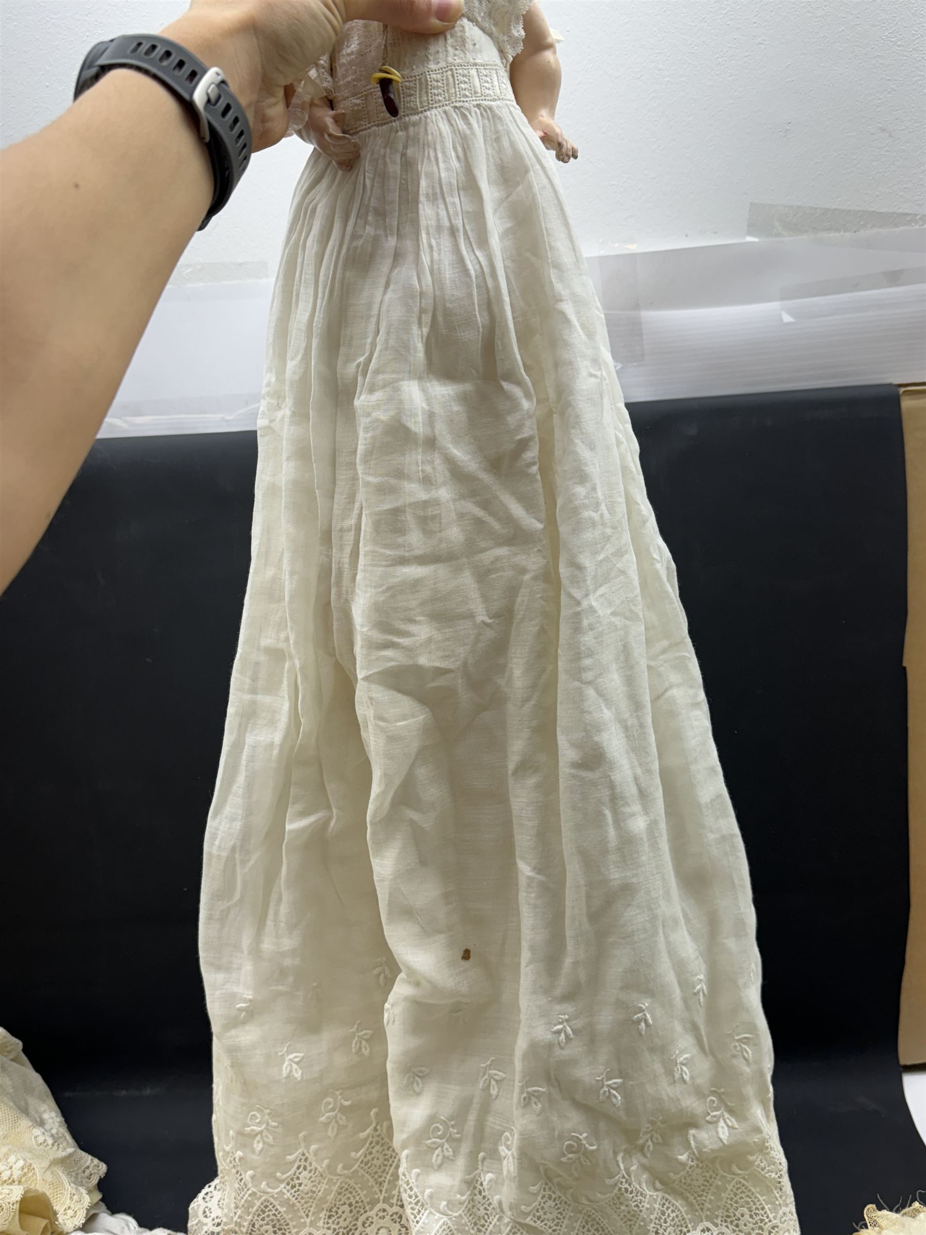 Two German bisque head dolls, to include a Franz Schmidt example with blue glass eyes and an Armand Marseille 590 example with applied hair, together with a Schoenau & Hoffmeister bisque doll's head, pair of doll's hands and a collection of clothing