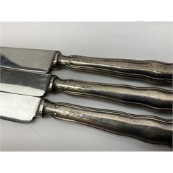 Two silver napkin rings, silver spoon with thistle top terminal, two silver handled butter knives, and small glass jar with silver cover, all hallmarked, approximate weighable silver 53.7 grams