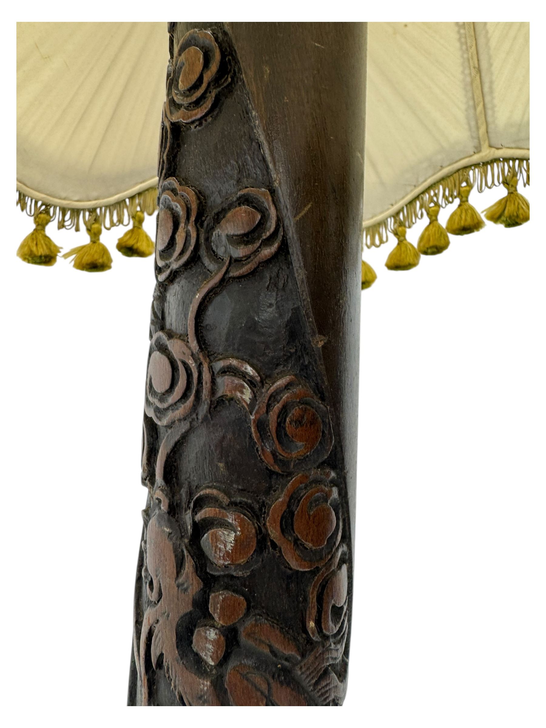 Early 20th century floor lamp, with fringed and pleated silk shade over a carved and turned column, on a circular stepped base