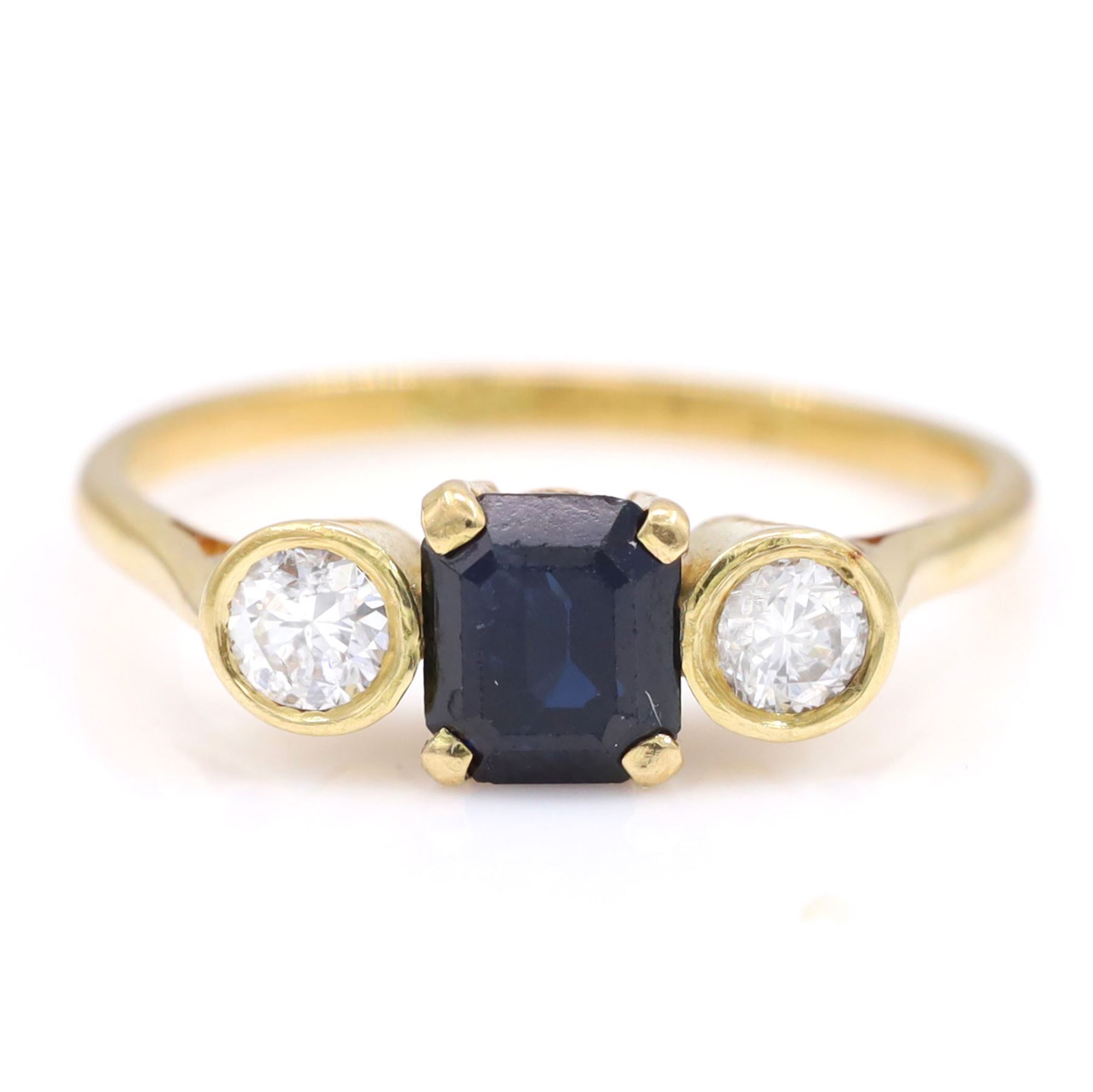 18ct gold sapphire and diamond three stone ring, single octagonal cut sapphire, with a single round brilliant cut diamond set either side, total diamond weight approx 0.25 carat