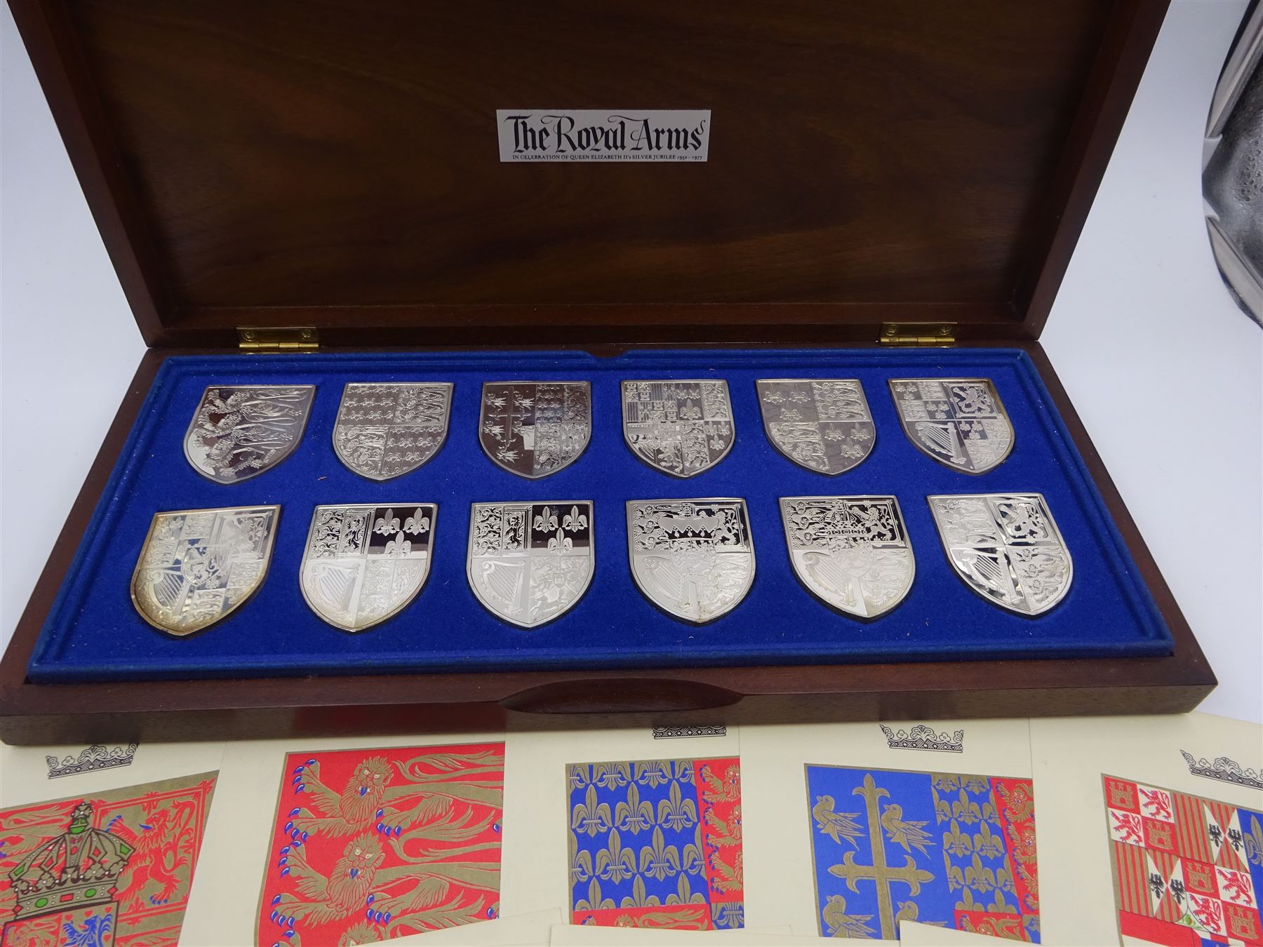 Yorkshire Mint, The Royal Arms Collection, twelve shield shaped silver medallions each depicting variations on the Royal coat of arms, each hallmarked Yorkshire Mint, Birmingham 1976/77, contained within fitted wooden case with associated information cards