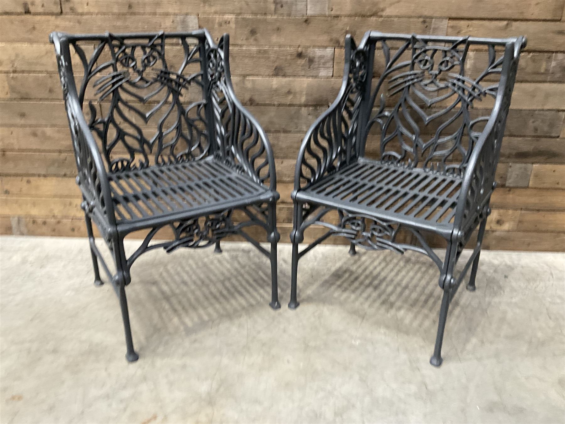 Richard Bawden (1936-2024): Pair of Cat design painted cast iron garden armchairs