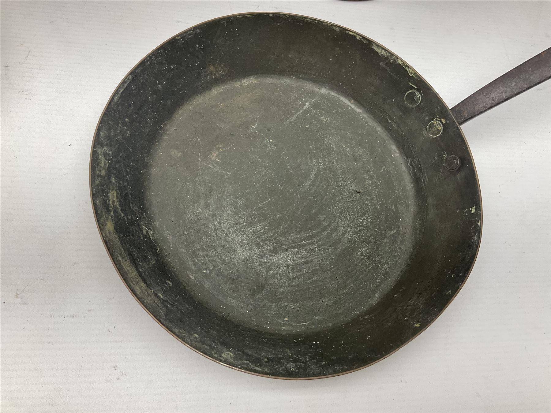 Four Victorian copper moulds, together with a graduating set of copper pans with wooden handles and finials to covers, largest pan 