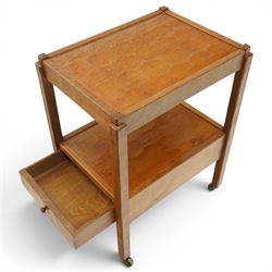 Acornman - oak two tier tea trolley, rectangular adzed top and lower section, with drawer raised on square supports terminating in castors, with carved acorn signature, by the workshop of Alan Grainger of Brandsby