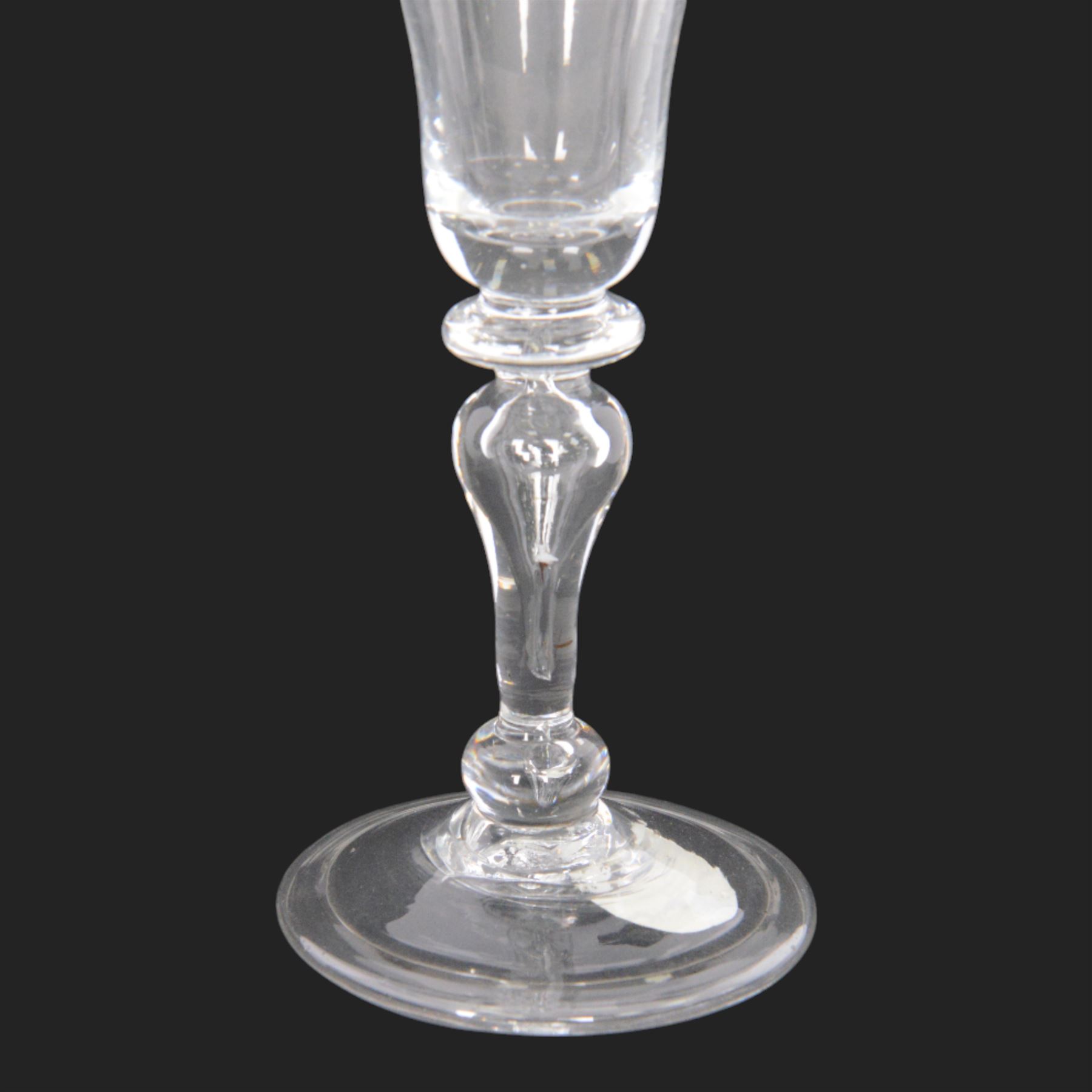 Mid 18th century wine glass, circa 1730-1740, with bell shaped bowl upon an inverted baluster stem with internal tear and basal knop, upon conical folded foot, H15cm