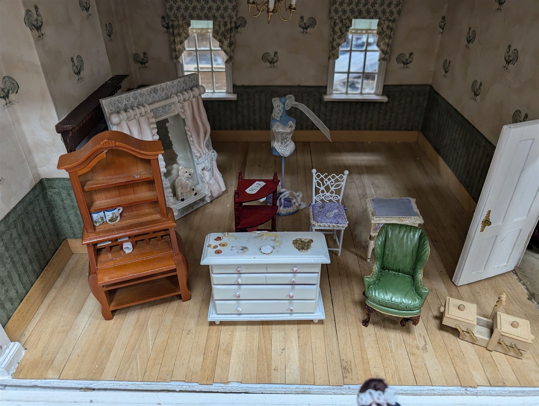 Two modern three storey dolls houses, each painted green with decorated interiors, both upon a single white wooden base, together with a large collection of dolls house furniture, accessories and figures 