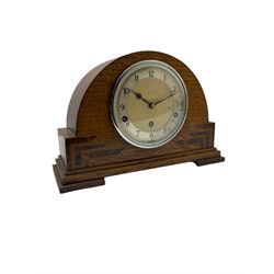 An English chiming mantle clock by Walker & Hall in an arched oak case with rosewood inlay, eight-day spring driven movement with a lever platform escapement, Westminster and Whittington chimes and chime/silent provision, dial with silver effect chapter ring, upright Arabic numerals and minute track, steel spade hands and concave glass within a chrome bezel.

