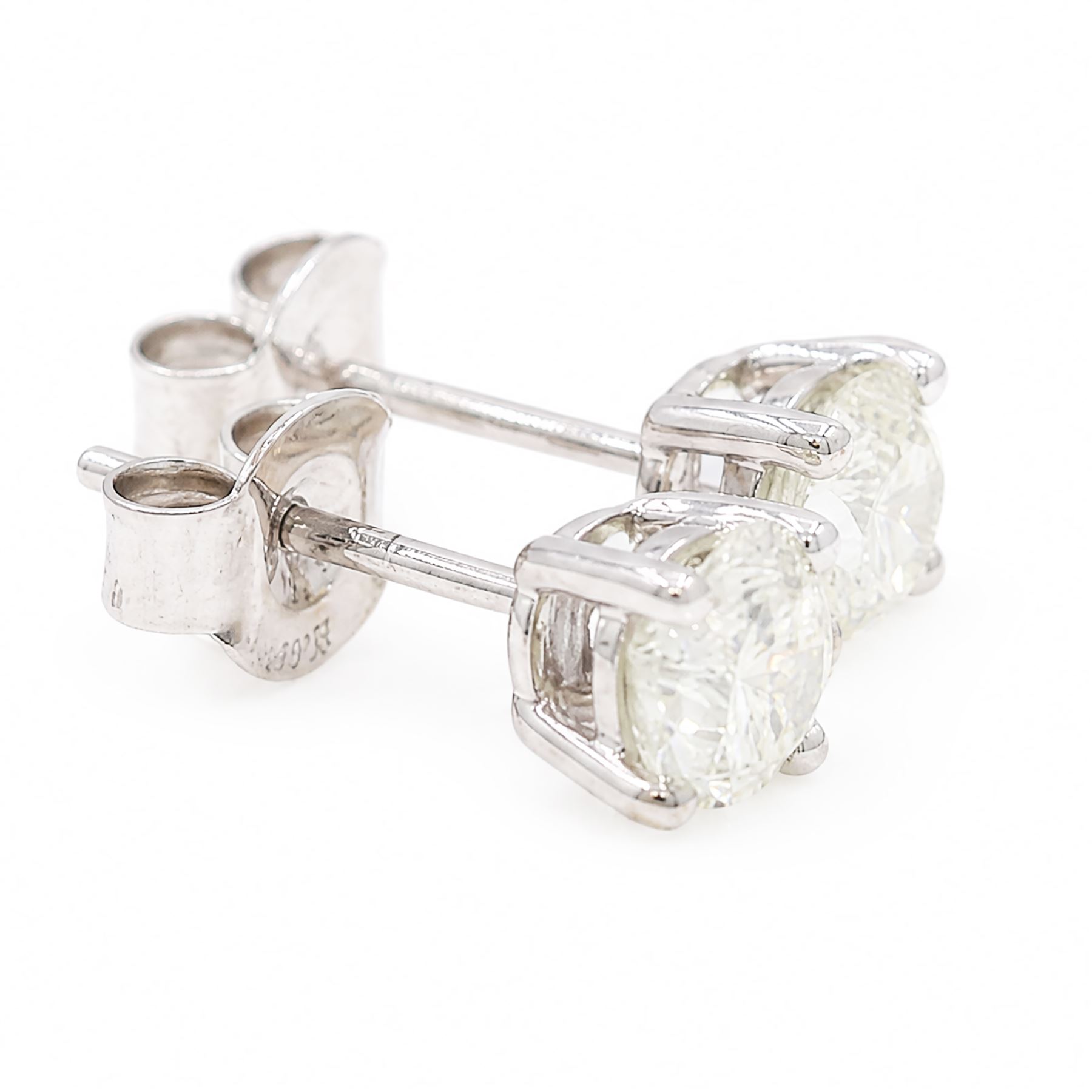 Pair of 18ct white gold diamond stud earrings, each stud set with a round brilliant cut diamond, stamped, total diamond weight approx 0.95 carat
