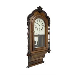 American - late 19th century 8-day wall clock, mahogany case with a carved surround, parqueterie inlay and finely turned pilasters, fully glazed case door with a painted dial, Roman numerals and spade hands, with a gold bordered mirror and faux mercury pendulum beneath, countwheel striking movement striking the hours on a bell. With key.
