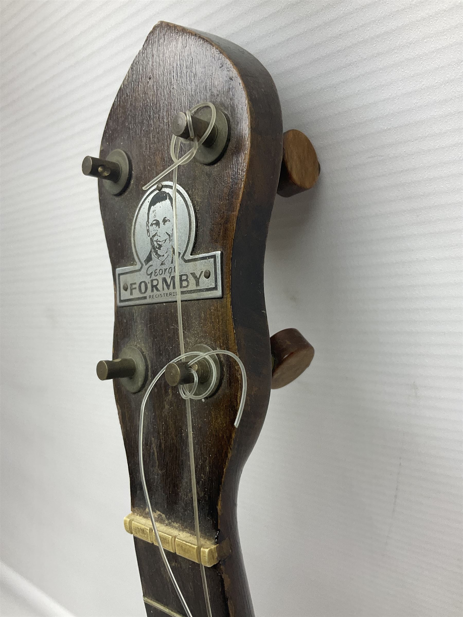 George Formby banjolele with metal plaque to headstock L55cm; in carrying case with instruction booklet.