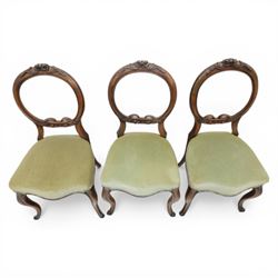 Victorian mahogany dining suite, oval tilt top dining table raised on a quatriform base with paw feet, together with a set of six balloon back dining chairs with green upholstery with cabriole legs 