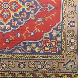 Turkish Malatya type flatwoven rug, decorated with a red medallion field, stylised floral motifs and blue corner panels, enclosed by beige foliate border and outer floral guard band