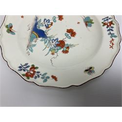 Mid 18th century Chelsea red anchor period plate, circa 1752-1754, hand painted in enamels in the Kakiemon palette with flowering peony and chrysanthemum issuing from rock work, and butterfly in flight above, the shaped rim detailed with conforming floral sprigs and butterflies within a iron red line border, with red anchor mark beneath, D22cm