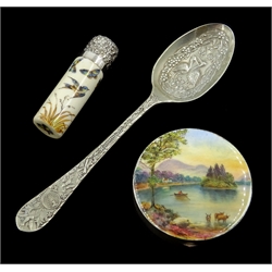  Silver and enamel compact with lake scene by Henry Clifford Davis Birmingham 1929 5cm, an Aesthetic Movement ceramic scent bottle with silver top by Mappin Brothers and a plated Aesthetic Movement spoon (3)  
