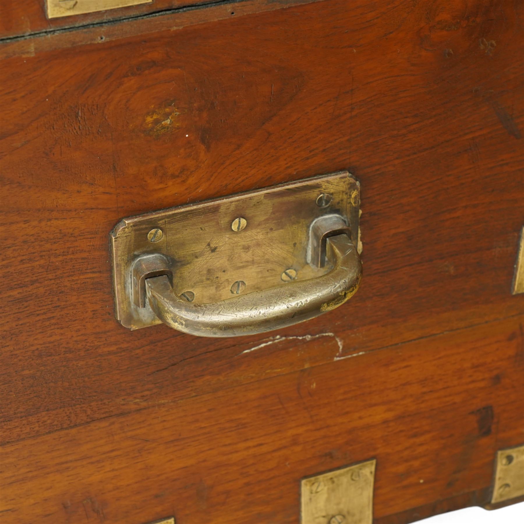 Early 19th century teak and brass bound silver campaign chest, fitted with brass L-shaped brackets and heavy weight carrying handles, the hinged lid enclosing two removeable trays with divisions and lined in blue baize, fitted with two 'R. Cooper & Son' brass locks