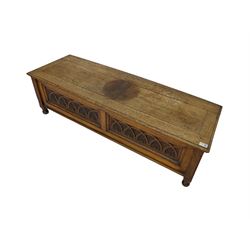 Early 20th century oak ‘bay window’ shaped blanket chest or coffer, hinged top, the front with two lunette carved panels flanked by fluted uprights, on turned feet