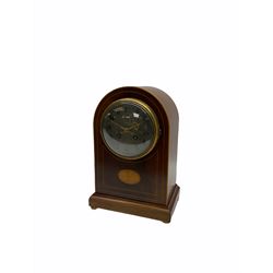 Edwardian eight-day Mahogany cased mantle clock striking the hours and half hours on a coiled gong, French rack striking movement with a recoil escapement, cast brass bezel with convex glass  enclosing a silver effect dial with upright Arabic numerals and brass gothic hands, round topped case with satin wood stringing and an oval fan paterae, surmounting a rectangular plinth on brass bun feet.
With pendulum and key.
