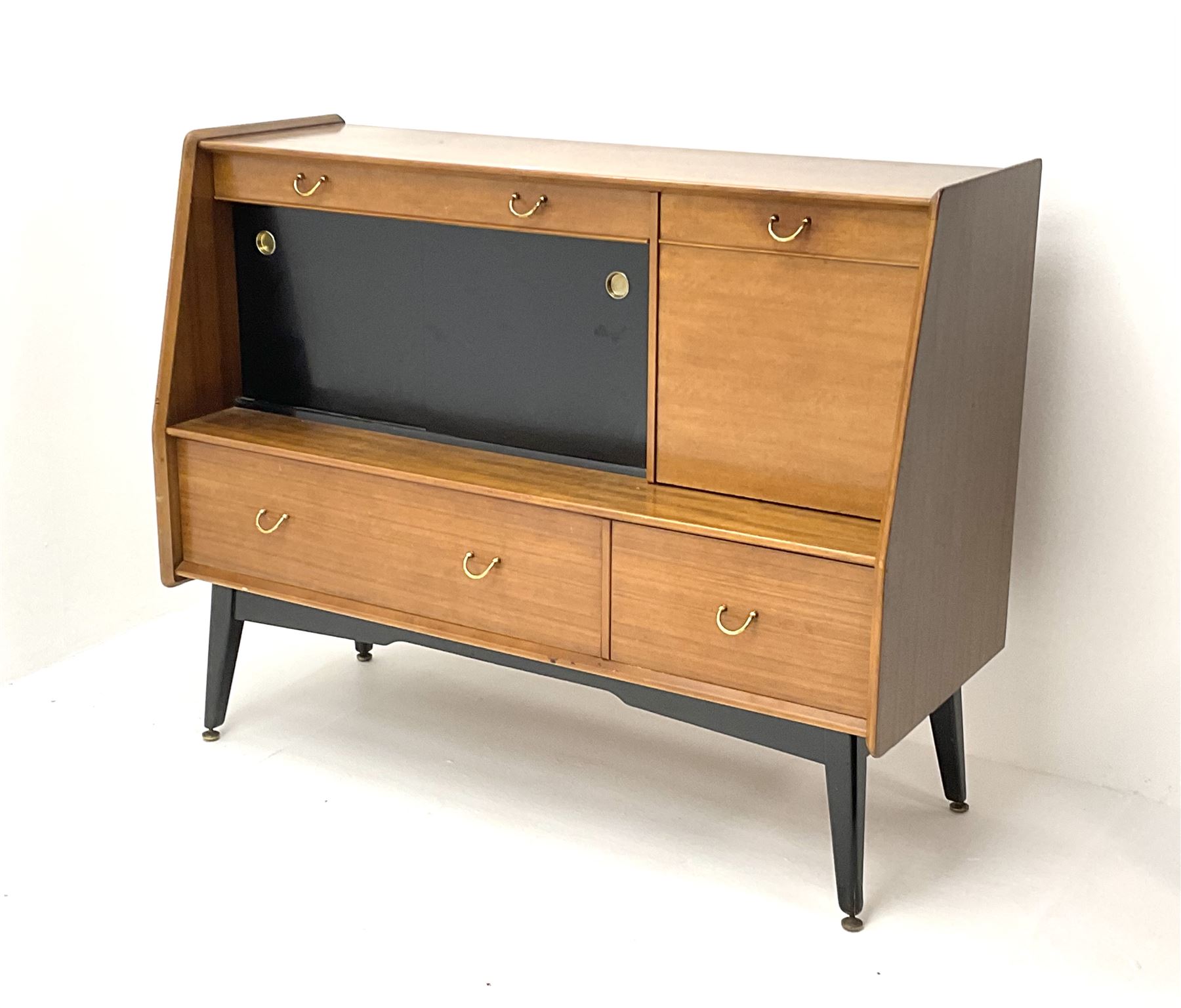 1950s G-Plan retro highboard unit, single long drawer above glazed sliding doors enclosing shaped glazed shelve, alongside a fall front door, above one short and one long drawer, raised on outsplayed tapering supports 