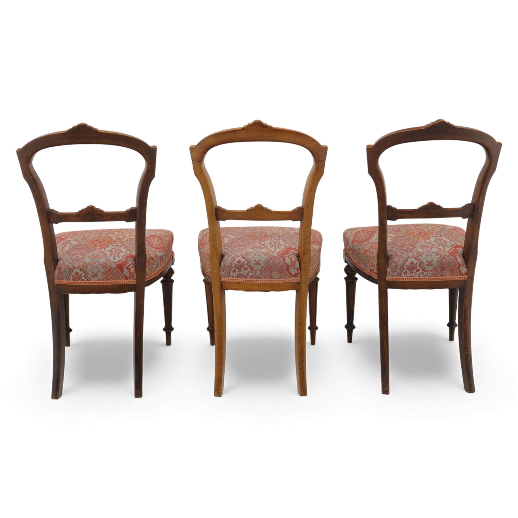 Set of six late Victorian mahogany dining chairs, the shaped top rails carved with anthemion motifs, above pierced splats, floral and geometric fabric seat, on turned and fluted front legs