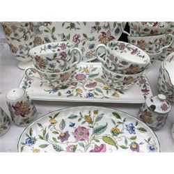 Minton Haddon Hall pattern tea and dinner wares, including basket dish, two covered tureens, six dinner plates, eight dessert plates, twelve tea plates, six soup bowls, six cereal bowls, teapot, coffee pot, milk jug, covered sucrier twelve tea cups and saucers, six mugs, footed bon bon dish, pair of candlestick holders, cake knife and slice etc (81)