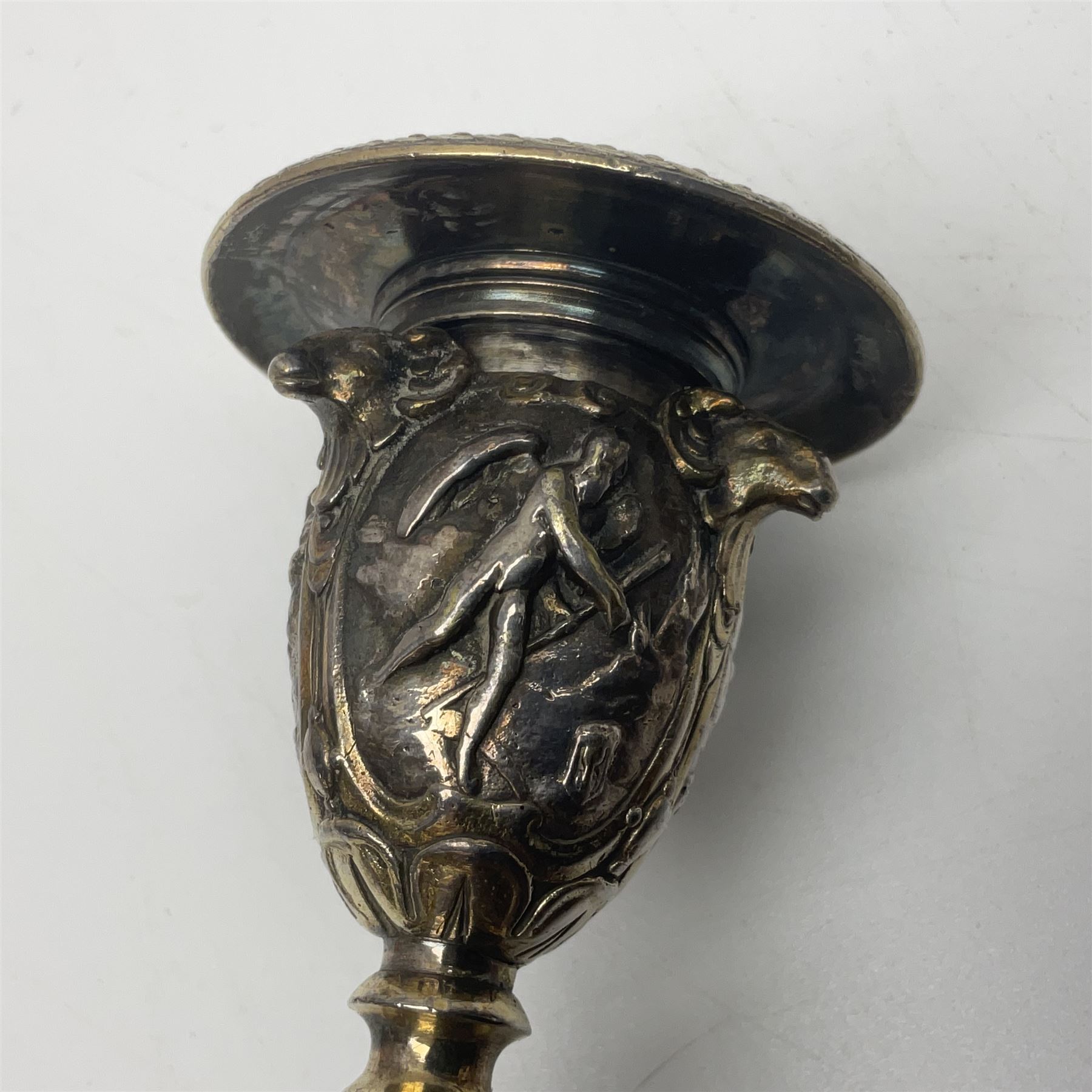 Pair of Victorian Elkington Mason & Co silver plated candlesticks, decorated in relief with ram masks and figures, H14cm