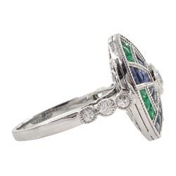 Platinum diamond sapphire and emerald target ring, the central round diamond surrounded by calibre cut sapphire and emeralds, with diamond set shoulders