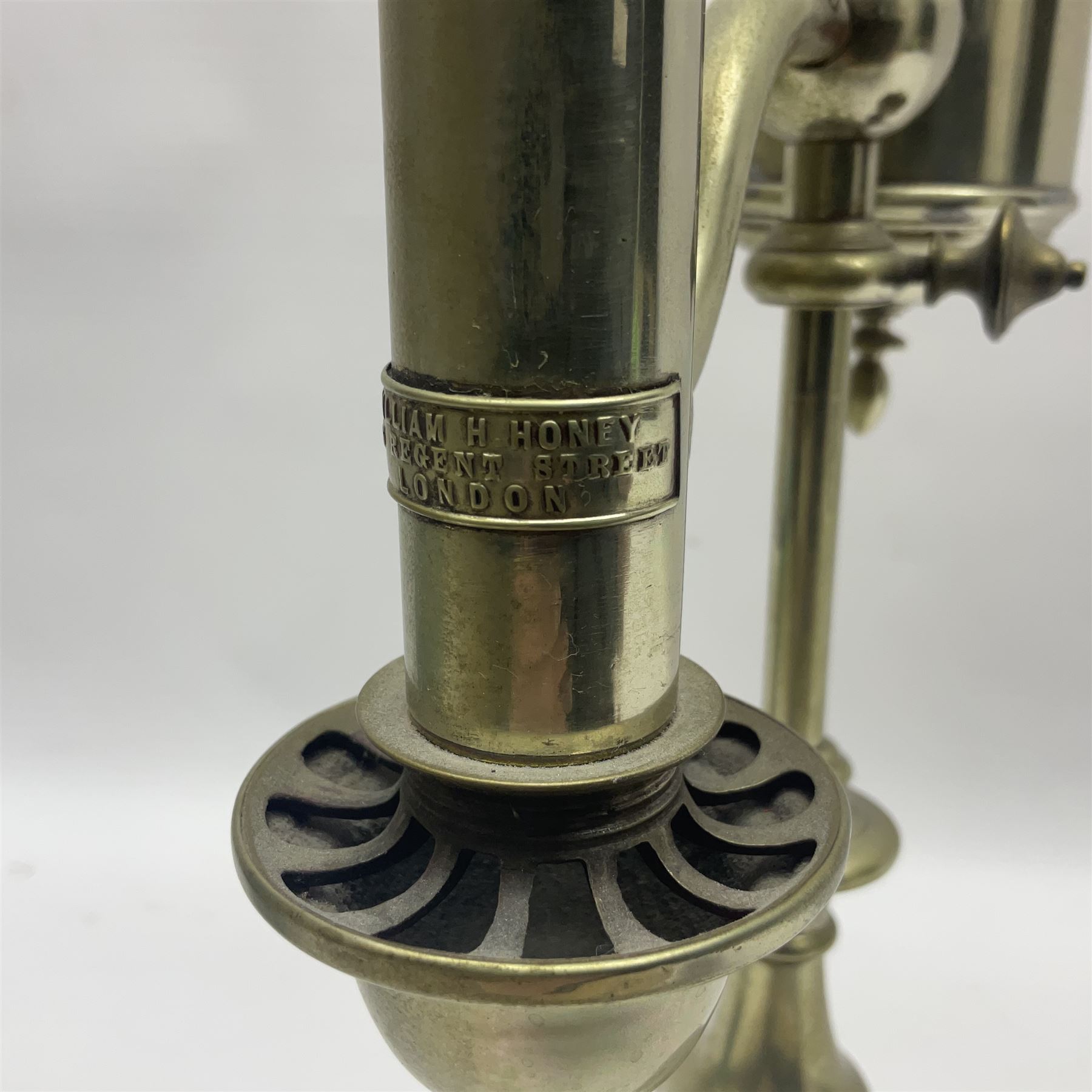 William H Honey polished brass adjustable student's oil lamp, with green glass shade, H60cm