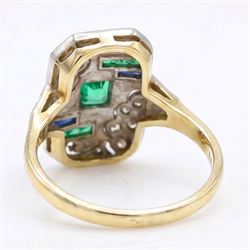 Art Deco 18ct diamond, emerald and sapphire panel ring, the rectangular floral pierced panel set with a single square cut emerald, surrounded by old cut diamonds and four rows of channel set calibre cut emeralds and sapphires, to diamond set shoulders 