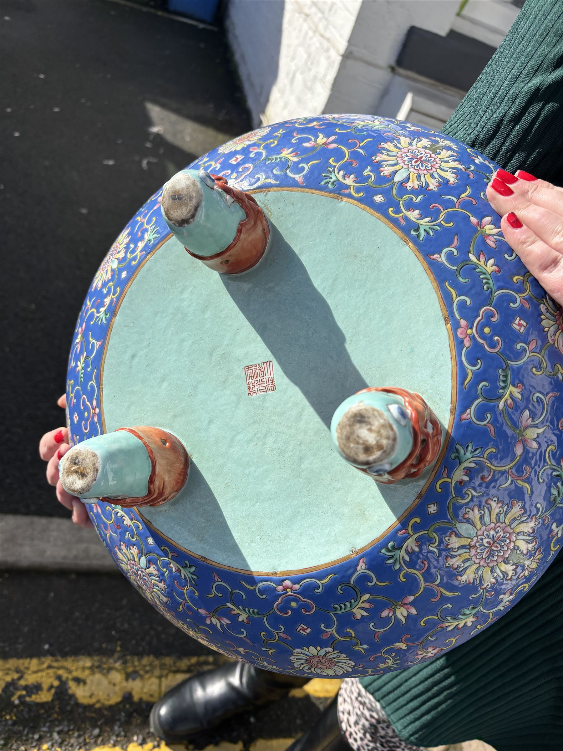20th century Chinese footed bowl, of circular form, decorated in polychrome enamels with flowers and foliage on a cobalt blue ground, upon three grotesque mounted feet, with character marks beneath, H13cm, D38cm