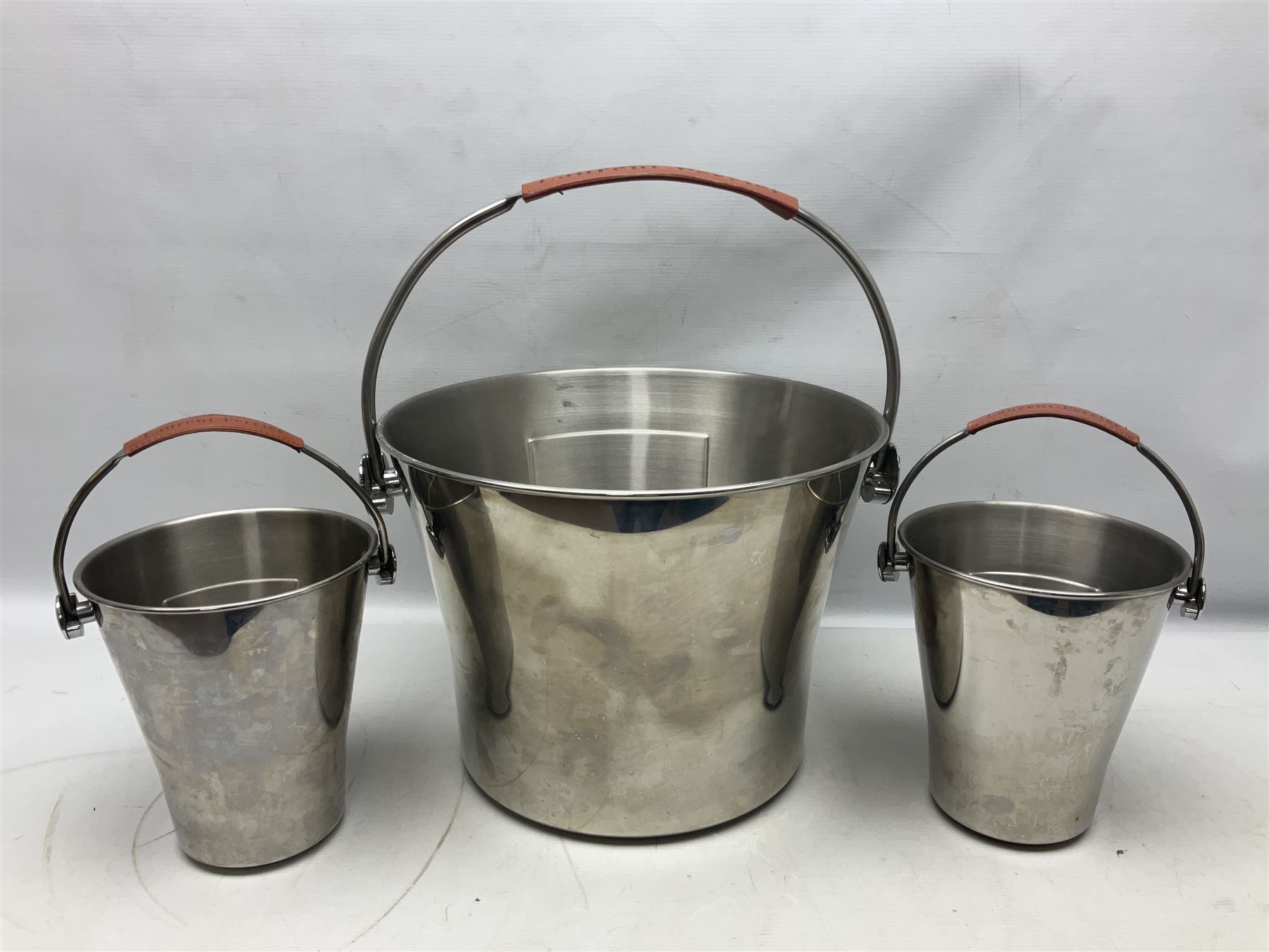 Stainless steel Laurent-Perrier champagne bucket, with engraved brass plaque and grip to swing handle, together with two matching smaller, largest D38cm (3)