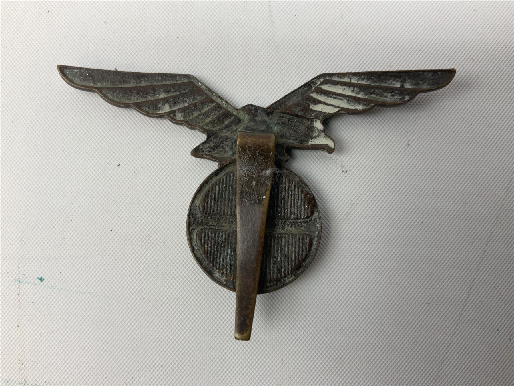 Three WW2 German visor cap badges comprising Police eagle, Political leaders eagle and Norwegian Quisling Party; all with fixings; and WW2 Polish visor cap badge (4)