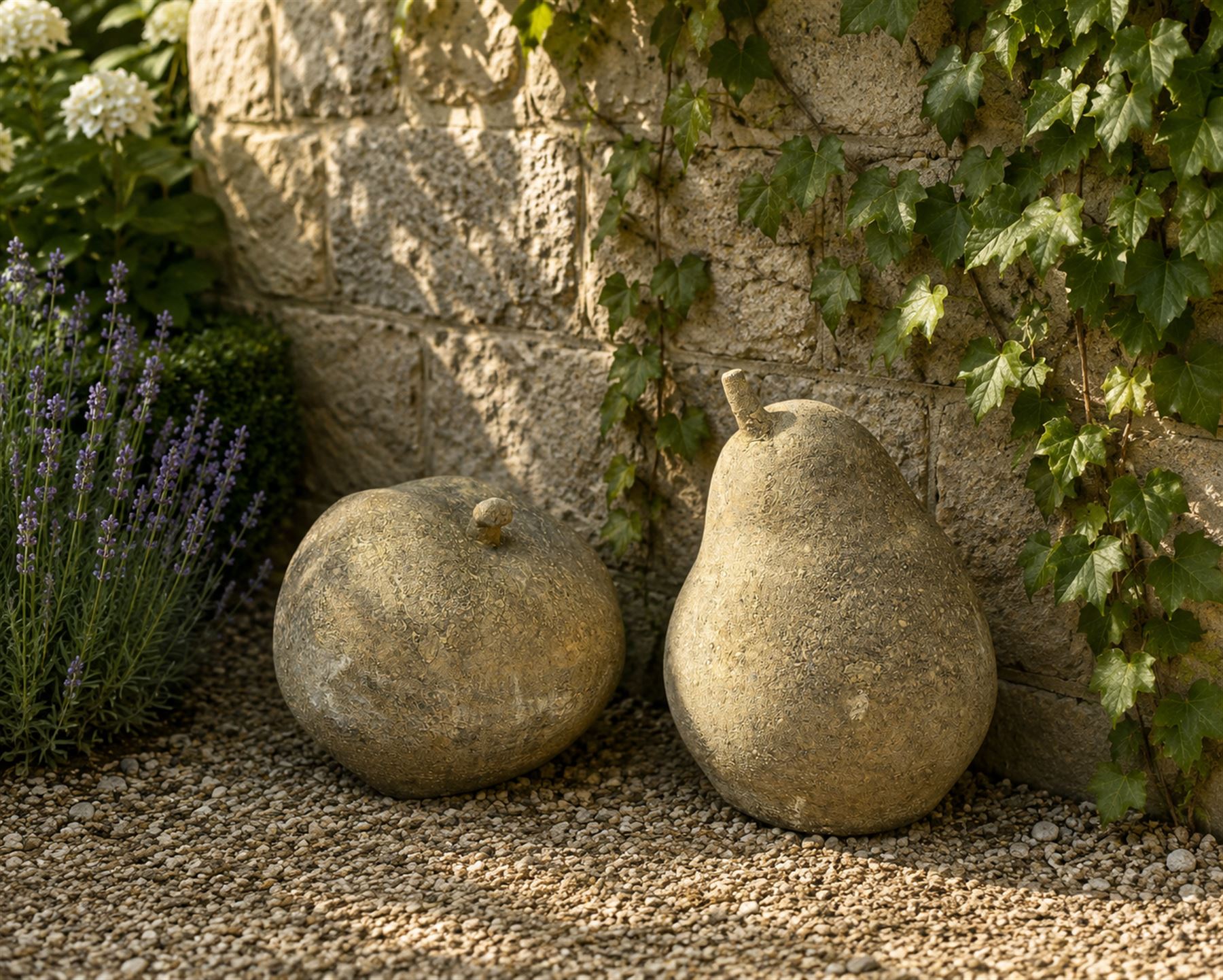 Pair of weathered cast stone garden models of fruit, in the form of an apple and pear