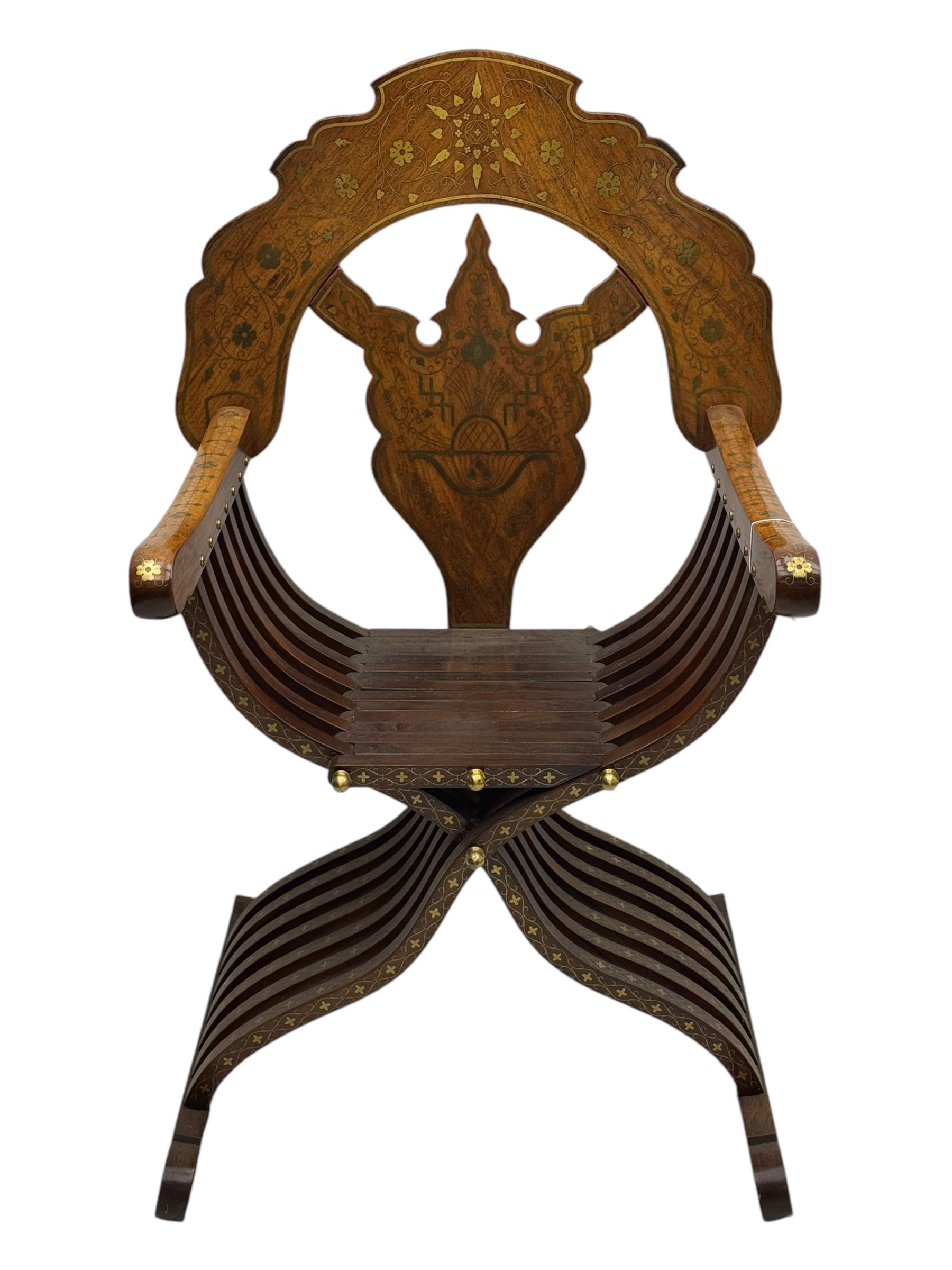 Late 20th century brass inlaid hardwood throne chair, curved X-frame form, raised shaped back inlaid with trailing leafy branches and flower heads, on sledge feet 