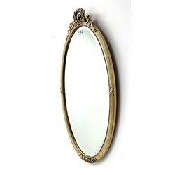 Oval shaped mirror, gold moulded edging with floral bouquet at the top