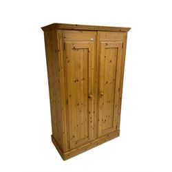 Solid pine double wardrobe enclosed by two panelled doors