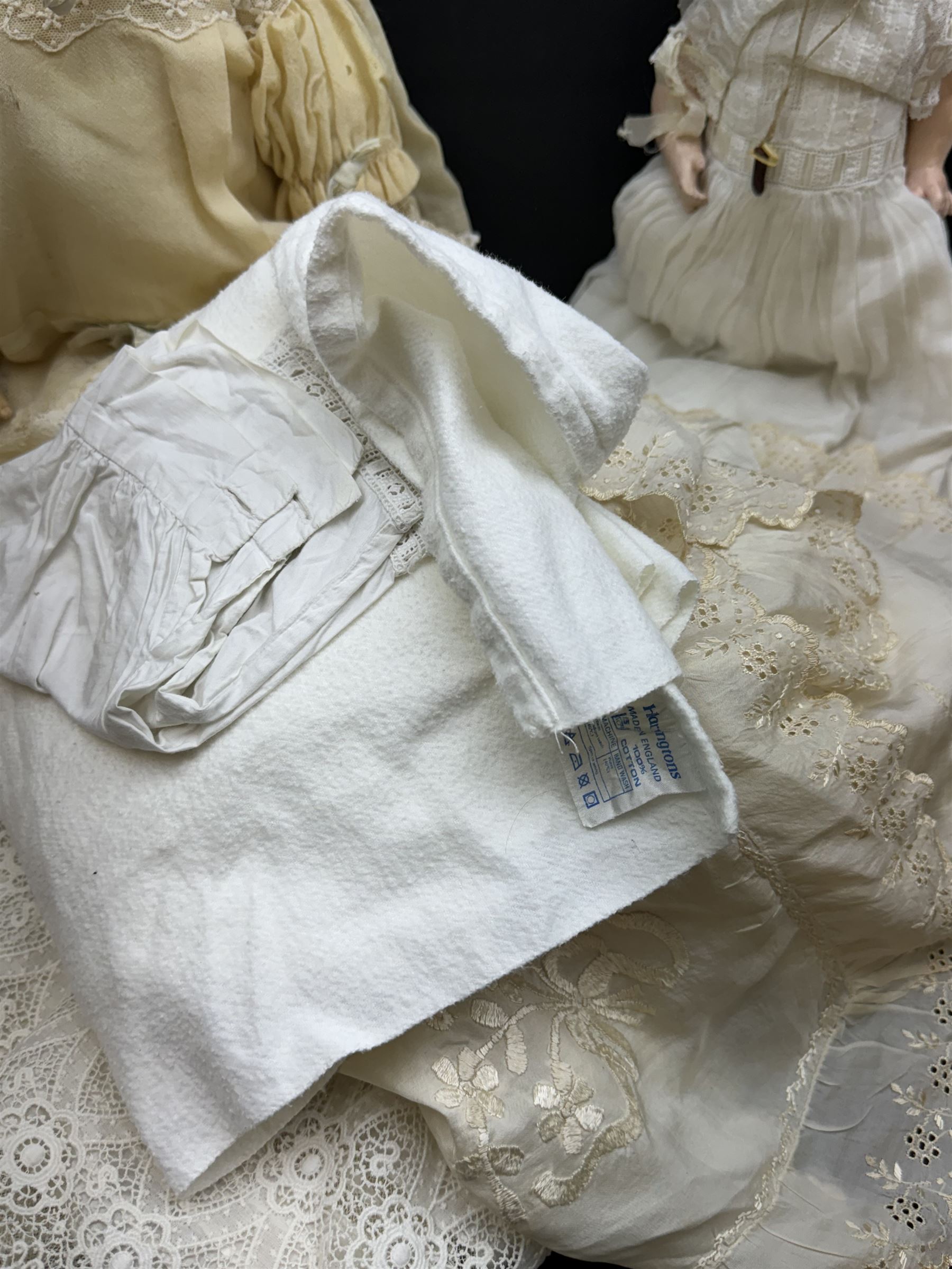 Two German bisque head dolls, to include a Franz Schmidt example with blue glass eyes and an Armand Marseille 590 example with applied hair, together with a Schoenau & Hoffmeister bisque doll's head, pair of doll's hands and a collection of clothing